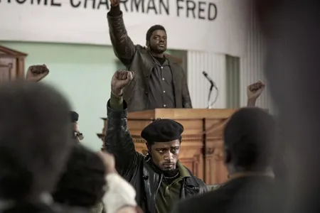 Informer William O'Neal (played by LaKeith Stanfield, seen wearing a beret in the foreground) provided the FBI with information used to plan Black Panther Party Chairman Fred Hampton's assassination (portrayed by Daniel Kaluuya, standing with hand raised at the podium).