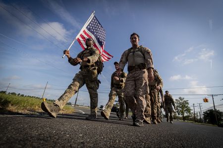 A service member carries a flag and leads his comrades at Joint Base McGuire-Dix-Lakehurst as they march in remembrance of 9/11 victims. More than 40 veterans died in the attacks.

