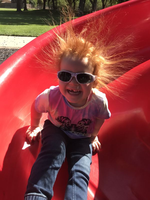 My granddaughter enjoying an electrifying run on a slide. thumbnail