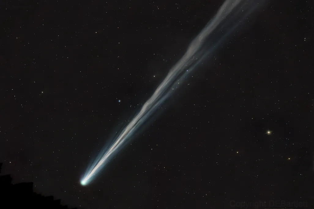 A white comet streaks across dark space