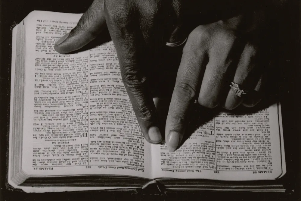 Two hands pointing to a Bible passage, ca. 1968