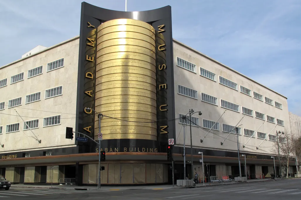 Large beige building with golden sign that reads Academy Museum