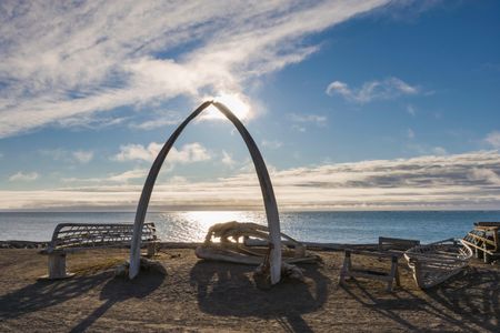 An arch made from a bowhead whale jaw stands over traditional whaling boats in Barrow, Alaska.