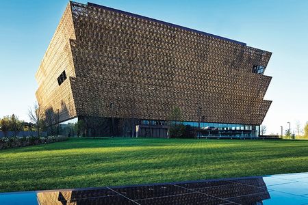 Wrapped in an ornamental bronze latticework, the angular lines of the Museum rise in stark contrast to the rich green landscape.