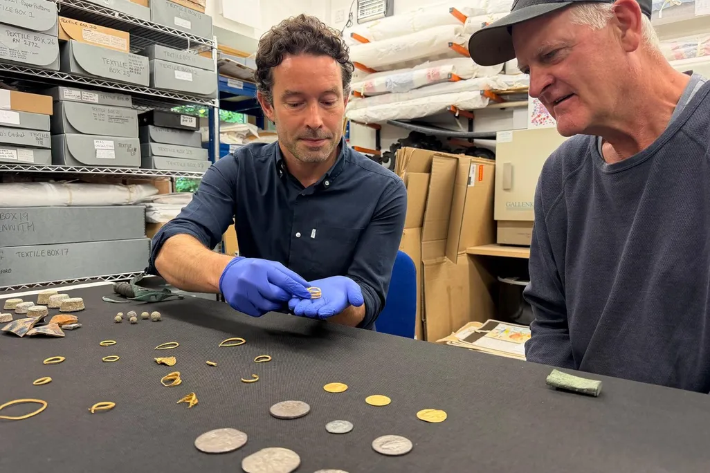 Isles of Scilly museum curator Xavier Duffy examinating recovered treasures with diver Todd Stevens