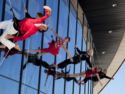 Sir Richard Branson (c) along with son Sam (left in black) and daughter Holly (far right) performing with Project Bandaloop on the side window wall of the Virgin Galactic Gateway to Space Hangar, Monday October 17, 2011 near Las Cruces, New Mexico.
It was part of a dedication and christening of the hangar to Virgin Galactic.