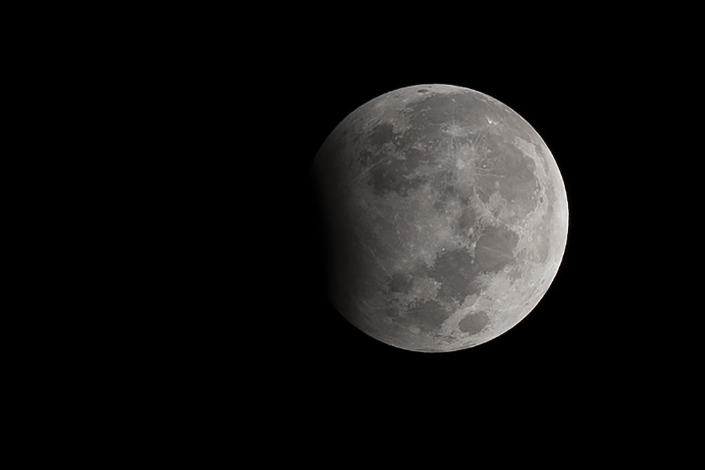 Moon against a black background with a shadow on its left side