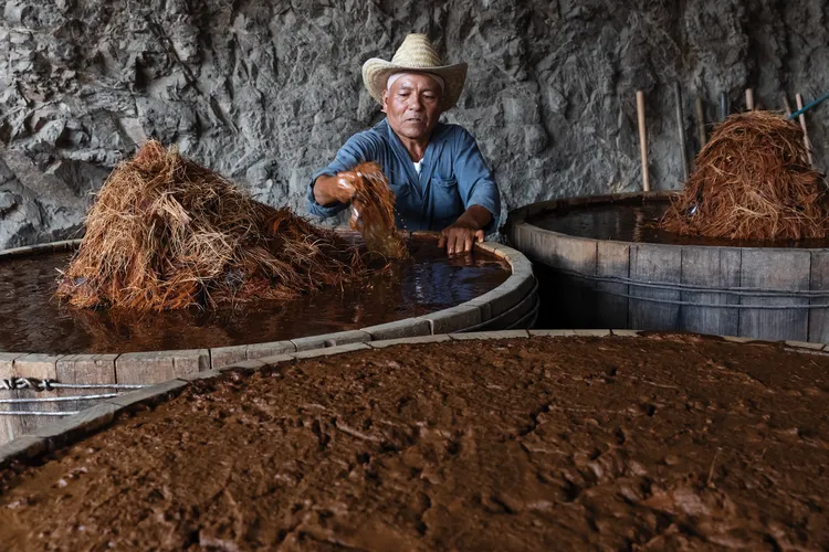 José Santiago of Palenque Don Lencho, in San Pablo Guilá village, with wooden vats of fermenting agave prior to distillation
