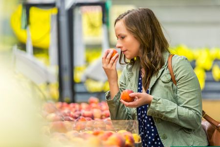 This woman won't do justice to the smell of this peach when she describes it to a friend later.