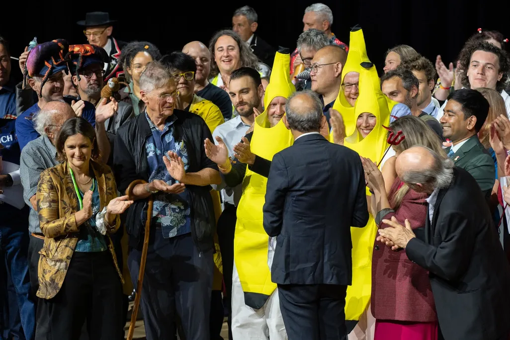 a crowd, including three people dressed as bananas