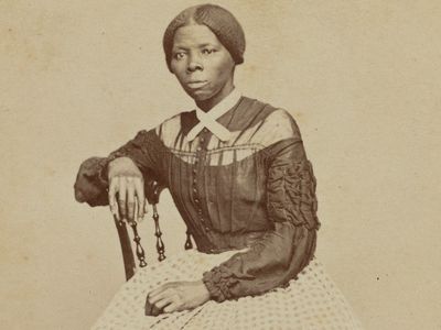 A crop of a carte-de-visite of Harriet Tubman seated in an interior room.