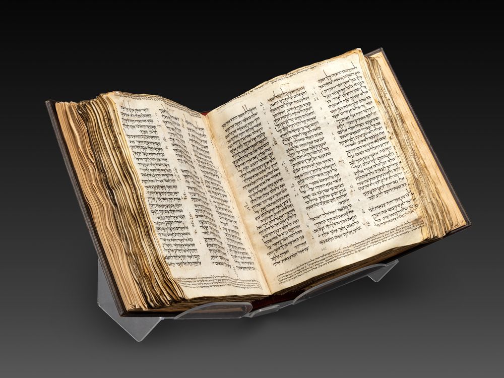 Bible open to a page in the middle, set against a black backdrop