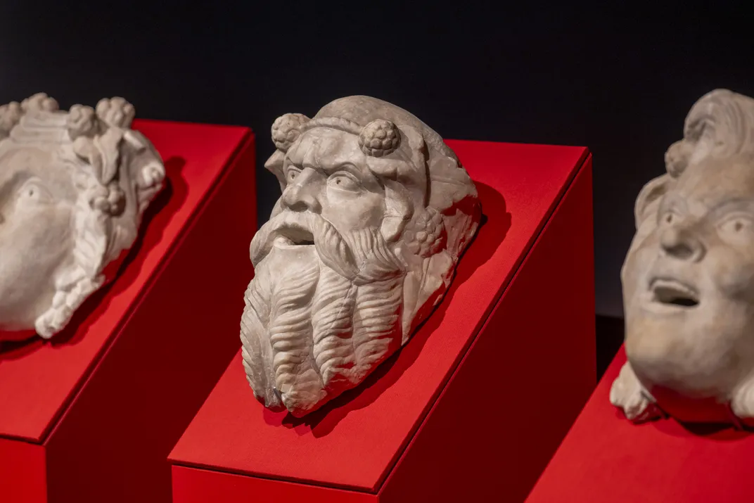 Sculptures of heads against red backdrops