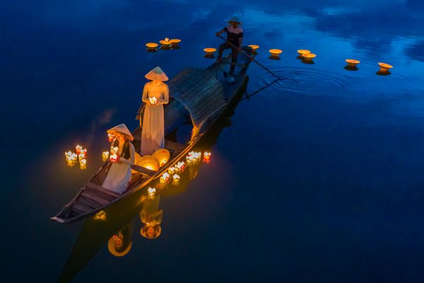 Women in traditional Ao Dai light lanterns on the Perfume river, Hue, Vietnam. thumbnail