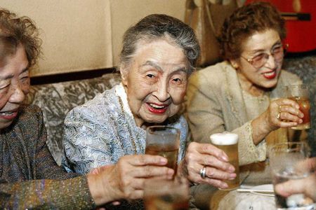 A bar proprietress drinks during her 101st birthday party at her tiny bar in Tokyo.