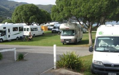 Caravans cram this campground in Akaroa in a scene typical of New Zealand. Cyclists and hikers, when camped among such fleets of vehicles, may wish for a patch of privacy somewhere in the nearest forest—if only there were access.