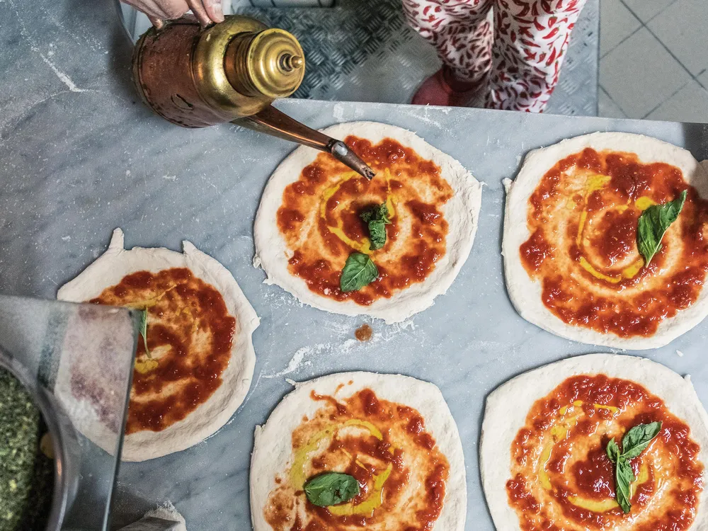 MOBILE - At Pizzeria Port’Alba, a cook prepares the ultimate food to go: pizza portafoglio