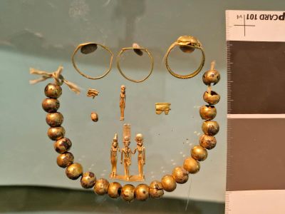The discoveries include gold-plated beads, eye-shaped amulets and a small statue of three Egyptian gods.