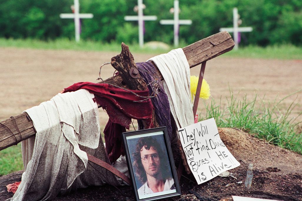 A photo of David Koresh rests beside a wooden cross