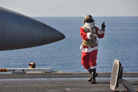 091225-N-8421M-103
NORTH ARABIAN SEA (December 25, 2009) Lt. Jon Sunderland dresses in a Santa suite while directing aircraft operations aboard the aircraft carrier USS Nimitz (CVN 68) Christmas Day.  Nimitz Carrier Strike Group is on a routine deployment to the region.  Operations in the U.S. 5th Fleet area of operations are focused on reassuring regional partners of the United States� commitment to security, which promotes stability and global prosperity.  (U.S. Navy photo by Mass Communication Specialist 1st Class David Mercil/Released)