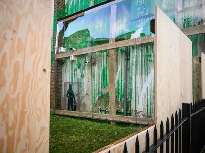 Wooden boards and plastic screens surround Banksy&#39;s latest confirmed artwork in London.