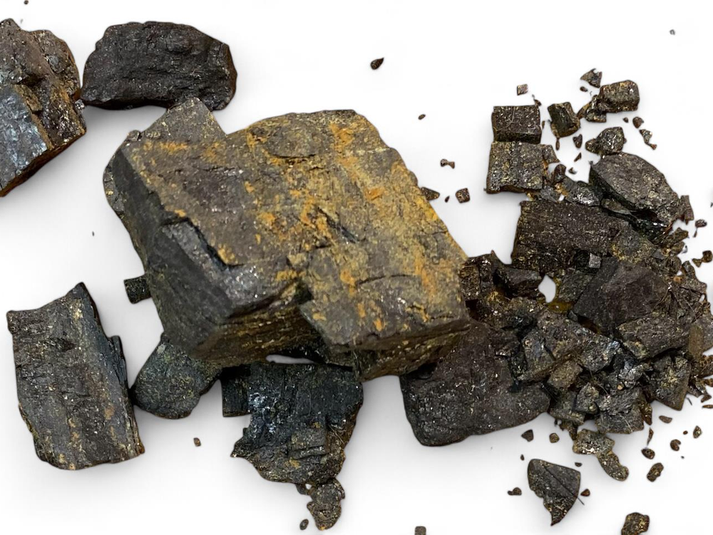 Broken pieces of coal against a white background