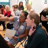 Two teachers sit side by side pointing out details in a museum gallery