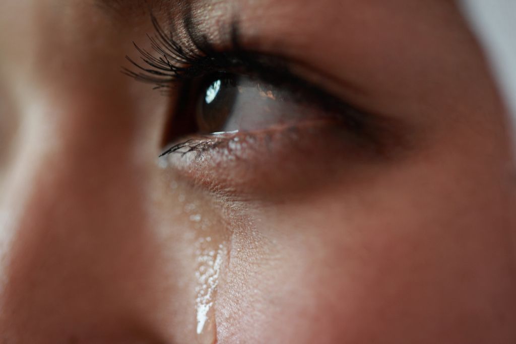 close-up of eye and tear on woman's cheek