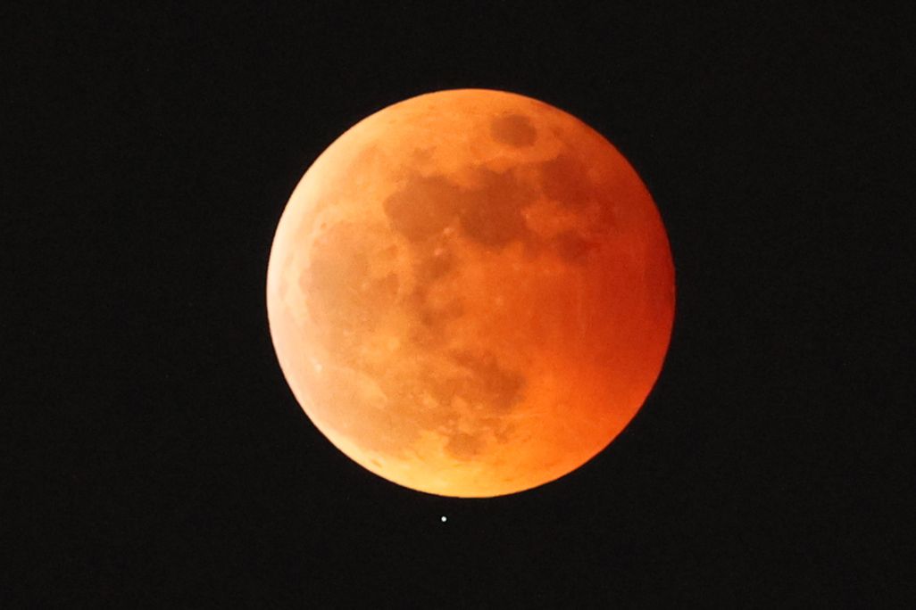 the moon appears orange and red in a lunar eclipse