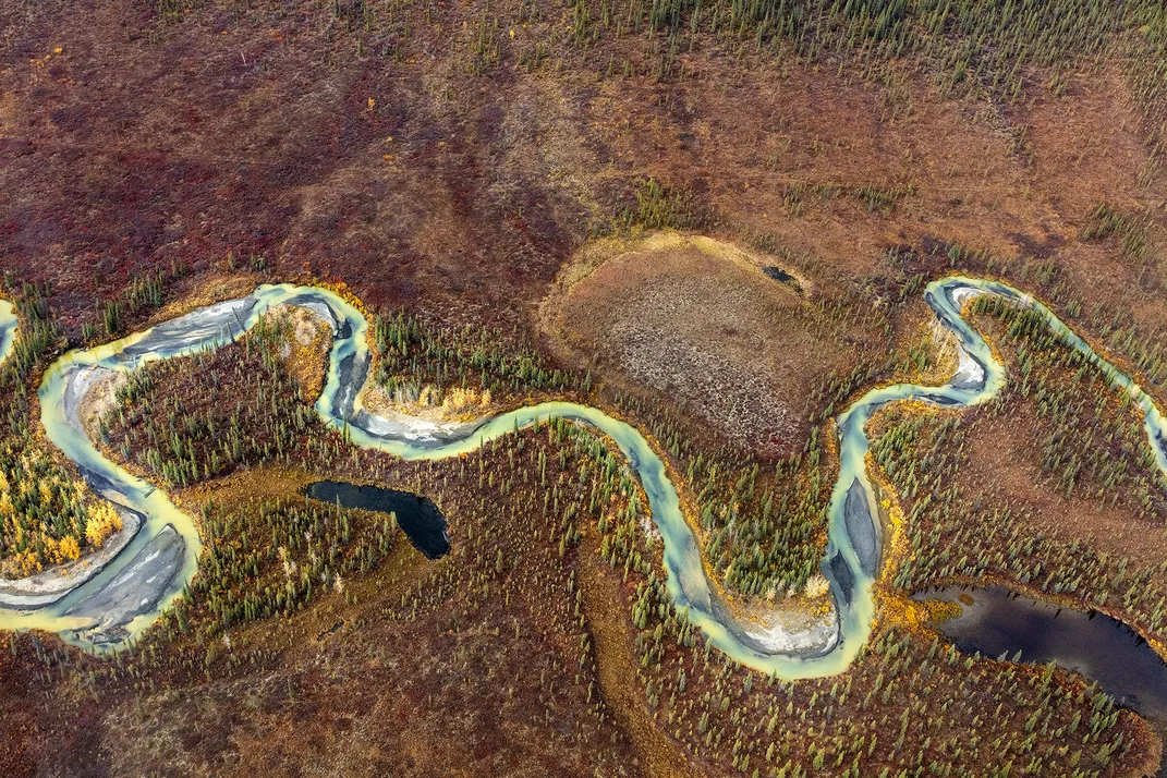an aerial view of a windy river surrounded by rocky terrain