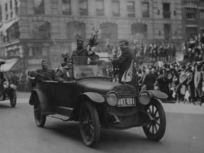 Sergeant Henry Johnson (standing, holding bouquet of flowers) and the Harlem Hellfighters at a 1918 victory parade in New York City