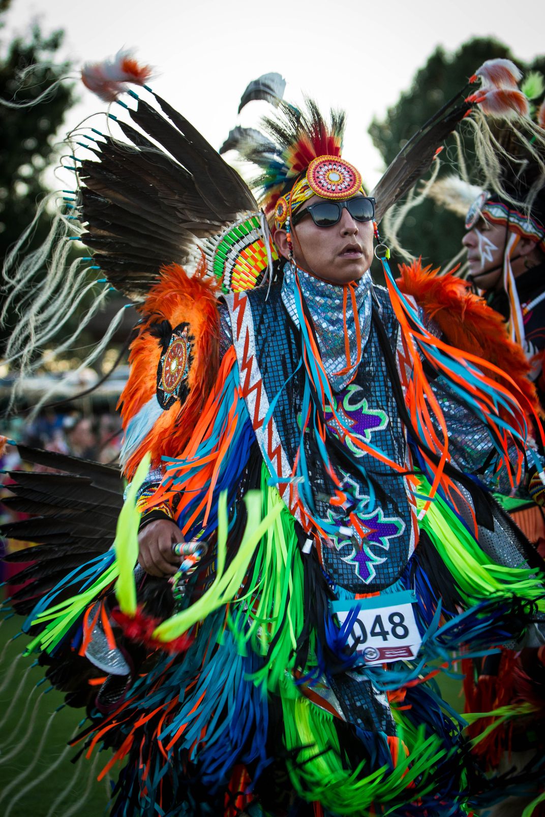 a Native dancer in colorful outfit and head dress