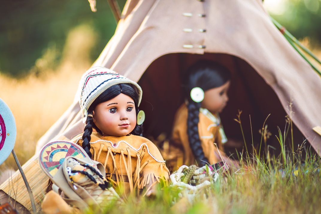 Kaya doll sitting outside in front of a teepee