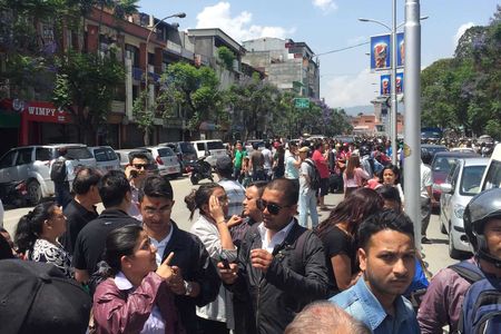 Local residents stand outside of buildings in the streets after a 7.5-magnitude earthquake, in Kathmandu, Nepal on May 12, 2015.