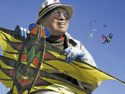 Artist Tyrus Wong, with kites of his own design, at California's Santa Monica Beach