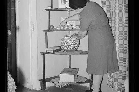 Woman arranging bric-a-brac in her Arizona home circa 1940