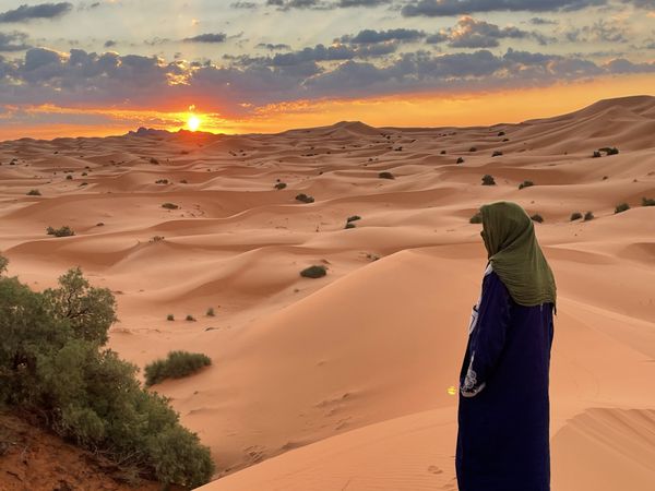 A Berber tribesman observing the sunrise over the Moroccan Sahara thumbnail