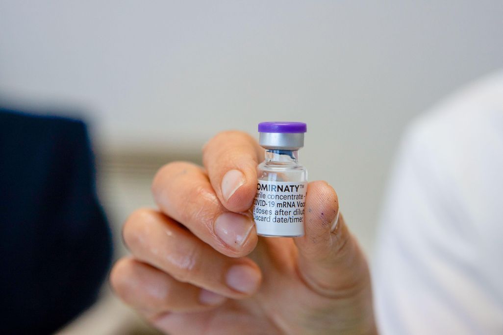 A hand holding the vial of Pfizer/BionTech's covid-19 vaccine