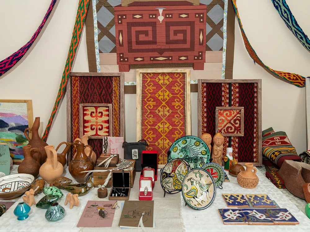 Several pieces of textiles, pottery, and other artwork arranged in an altar.
