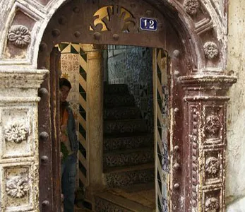 A boy peeks through a doorway that serves as the main entrance of a house.