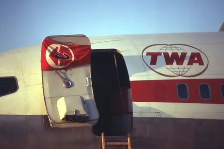 The Popular Front for the Liberation of Palestine&#39;s flag hangs on the door of a hijacked TWA Boeing 707 at Dawson&#39;s Field in Libya in September 1970.