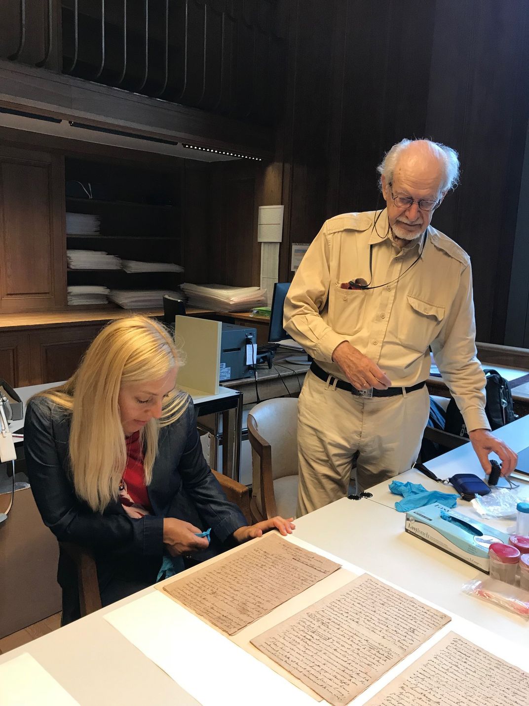 two people study historic manuscripts