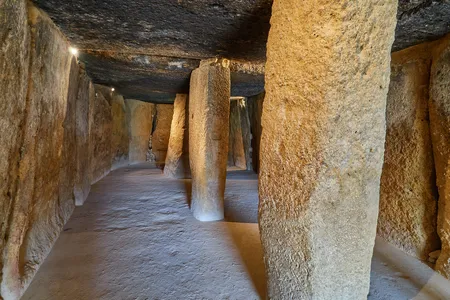 The interior of the Menga dolmen features large stone columns that help support the structure.