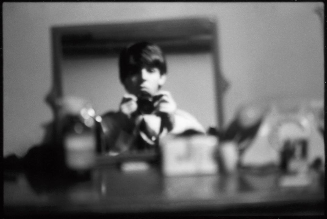 Paul McCartney taking a photo of himself in the mirror
