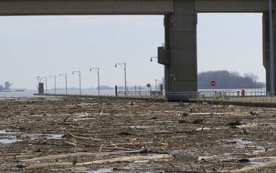 Flood debris on the Ohio River is halted by a dam
