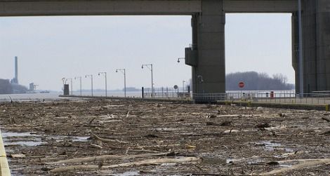 Flood debris on the Ohio River is halted by a dam