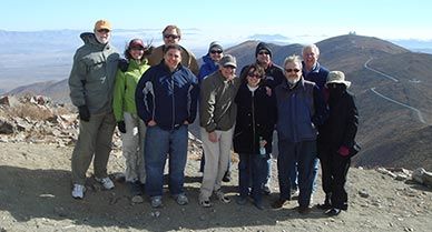 The team gathers at the top of the proposed Giant Magellan Telescope site on top of Las Campanas looking back toward the twin Magellan telescopes and homebase.