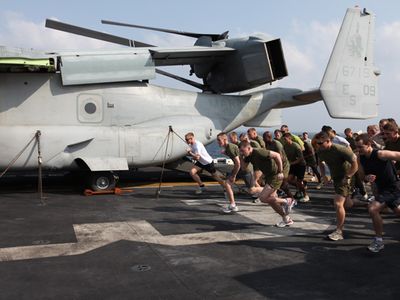 Marines and sailors with 26th Marine Expeditionary Unit and sailors  assigned to USS Kearsarge sprint from the starting line during the "Turkey Trot" 5K  held on the flight deck of USS Kearsarge,  Thanksgiving day,  Nov. 25, 2010. 26th MEU is deployed aboard the ships of the Kearsarge Amphibious Ready Group in the 5th Fleet area of responsibility and acting as the theater reserve force. (Official USMC photo by Lance Cpl. Tyler Logsdon/ Released)