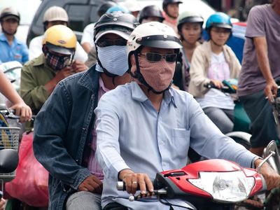 Commuters in Ho Chi Minh City, Vietnam use makeshift face masks to protect them from smog. Doctors are warning that climate change will affect human health, in part by increasing air pollution.