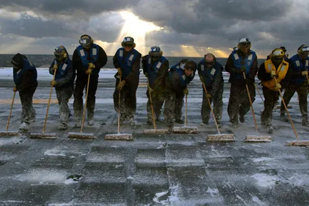 U.S. Navy flight deck personnel perform a scrubbing exercise during a counter measure wash down of Aqueous Film Forming Foam on the flight deck of USS Theodore Roosevelt (CVN 71) Dec. 4, 2007. The nuclear powered aircraft carrier is currently underway conducting training exercises. (U.S. Navy photo by Mass Communication Specialist 3rd Class Jonathan Snyder) (Released)